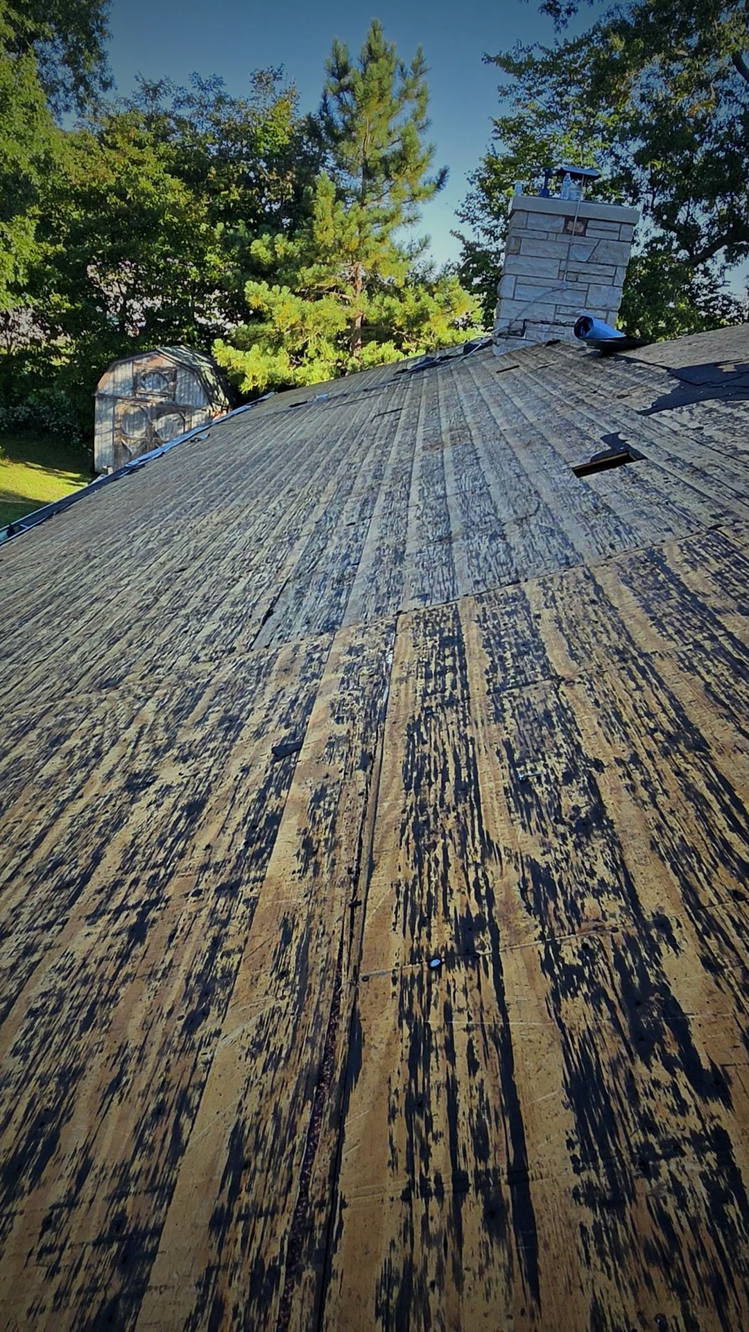 Beginning of the roof replacement with the old roofing removed down to the decking around the chimney